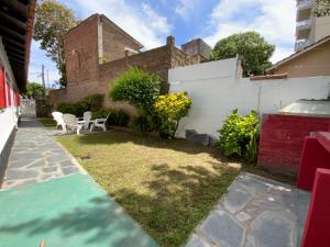 un pequeño patio con sillas y una valla blanca en Complejo Quimey No se alquila a jóvenes y se reserva con el 30 porciento del total mediante depósito bancario, en Villa Gesell