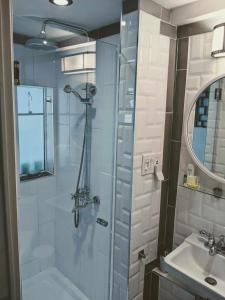 La salle de bains est pourvue d'une douche et d'un lavabo. dans l'établissement Le Ricochet Urbain, à Québec