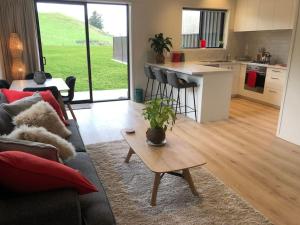 a living room with a couch and a table at Brightside Cosy Farmstay in Papamoa