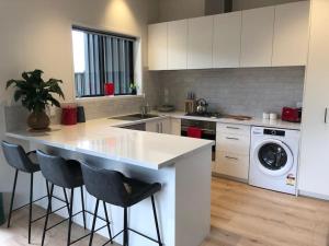 a kitchen with a counter and a washing machine at Brightside Cosy Farmstay in Papamoa