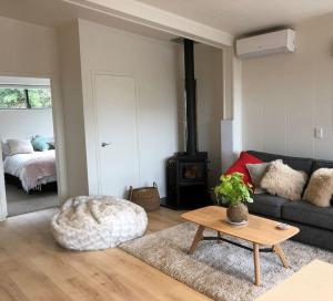 a living room with a couch and a table at Brightside Cosy Farmstay in Papamoa
