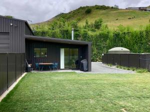 a house with a backyard with a table and a fence at Brightside Cosy Farmstay in Papamoa +25 photos