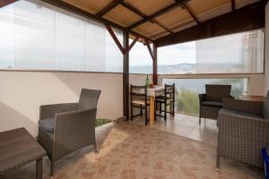 a dining room with a table and chairs and windows at Apartments by the sea Sveti Marko, Pag - 21654 in Pag