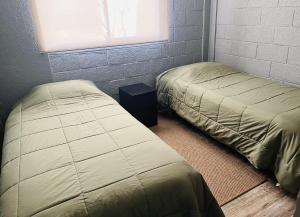 2 camas individuales en una habitación con ventana en Departamento Refaccionado y centrico, en Vicuña