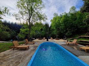 una piscina con 2 sillas y una mesa en Ecos del Manantial en Villarrica