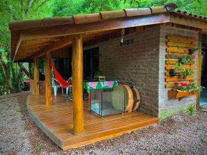 un gazebo avec une table sur une terrasse dans l'établissement Aldeia Pé da Serra Cabana Natureza, à Três Coroas