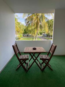 un tavolo e due sedie in una stanza con finestra di Appartement tout confort ! Au pied de la plage ! a Sainte-Anne