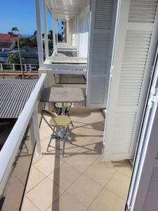 a small balcony with a chair and a desk on it at Apto 2 quartos - 250 m da praia de Atlântida in Xangri-lá