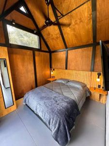 una camera con un letto in una piccola stanza di Casa Lanzo, montañas y lago a Macanal