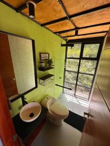 a bathroom with a sink and a toilet and a window at Casa Lanzo, montañas y lago in Macanal