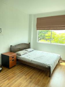 ein Schlafzimmer mit einem Bett, einer Kommode und einem Fenster in der Unterkunft Anna温馨公寓式的住宅 in Kuching