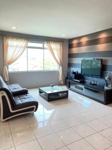 sala de estar con sofá y TV en Anna温馨公寓式的住宅 en Kuching