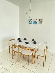 a white table and chairs in a room at Anna温馨公寓式的住宅 in Kuching