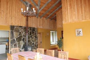 ein Esszimmer mit einem Tisch und einem Steinkamin in der Unterkunft Casa principal del Fundo con la mejor Vista del Maule in Comalle