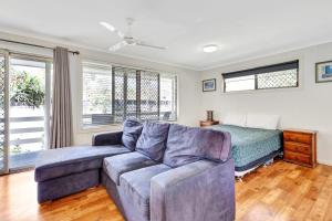 a living room with a couch and a bed at Sanctuary Lakes Fauna Retreat in Hervey Bay