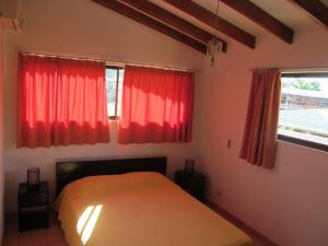 a bedroom with red curtains and a bed in it at Marfi Inn in Cahuita