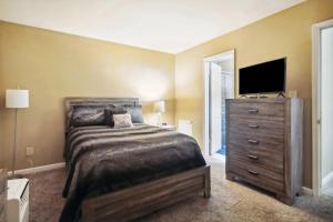 a bedroom with a bed and a dresser with a television at Urban Oasis Retreat in the Southwest! in Huntsville