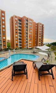 a deck with two chairs and a swimming pool on a building at Alojamiento en Pereira in Pereira