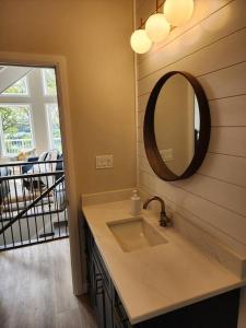 a bathroom with a sink and a mirror on the wall at Luxury Waterfront Cottage on Little Doe Lake in Burks Falls