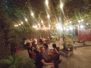 a group of people sitting in a patio at night at Kawoq Hostel in San Ignacio