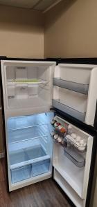 um frigorífico com a sua porta aberta com comida no interior em Entire Cozy Basement Studio in Winnipeg South Transcona em Winnipeg