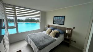 a bedroom with a bed and a swimming pool at Departamento Playa Las Cruces LagunaMar 3D2B con KYAK in Las Cruces