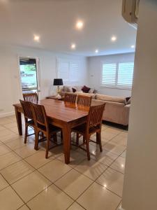 a living room with a wooden table and chairs at Moore Park Apartments in Armidale