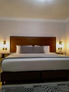 ein großes Bett in einem Hotelzimmer mit zwei Lampen in der Unterkunft Añoranza Hotel Boutique in Ciudad Hidalgo