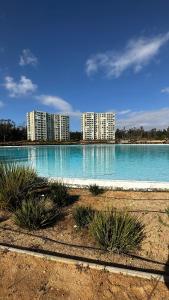 una gran piscina de agua azul con edificios al fondo en Departamento Playa Las Cruces LagunaMar 3D2B con KYAK en Las Cruces