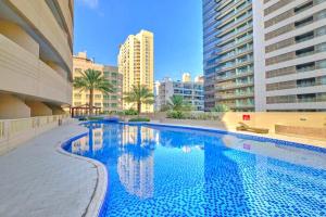 a large swimming pool in a city with tall buildings at Luxury 1 Bedroom On Marina Walk in Dubai