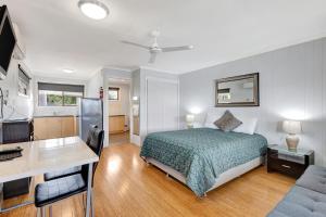 a bedroom with a bed and a desk and a desk at Sanctuary Lakes Fauna Retreat in Hervey Bay