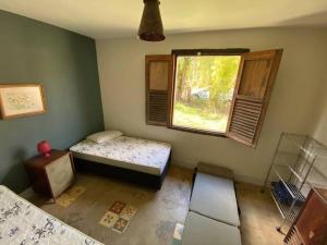 a room with a bed and a window in it at Casa Especial em Catas Altas in Catas Altas