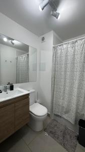 y baño con aseo, lavabo y ducha. en Departamento Playa Las Cruces LagunaMar 3D2B con KYAK en Las Cruces