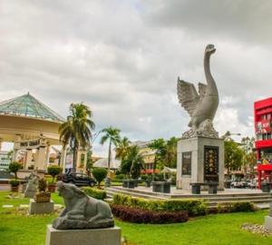 a statue of two birds in a park near a building at Anna 温馨住家住宅 in Sibu