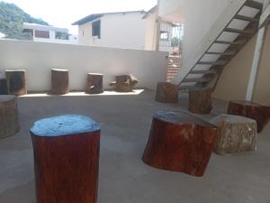 a group of wooden stools sitting next to a building at Hostel Leonardo Quarto com cama de casal in Vitória