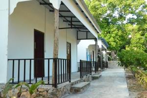 a house with a porch with a gate and trees at Fat Monkey in Koh Rong Island