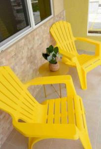dwa żółte krzesła i stół z doniczką w obiekcie Lemonade (With breakfast Option, Beach Access) w Negril
