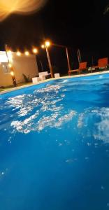 a swimming pool with blue water at night at Finca Los Chichelos in Santiago del Estero