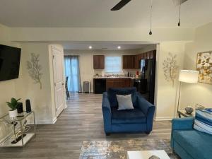 a living room with a blue chair and a kitchen at Modern Wi-Fi, Pet friendly home for Families in Greenville