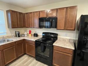 a kitchen with wooden cabinets and a black stove at Modern Wi-Fi, Pet friendly home for Families in Greenville