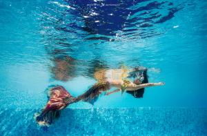 Eine Frau schwimmt im Wasser in der Unterkunft AERO氧程巴厘岛潜水度假酒店 in Tulamben