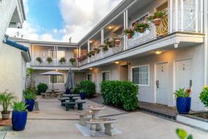 een binnenplaats van een gebouw met banken en potplanten bij Ocean Park Inn in Los Angeles