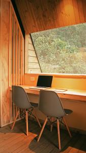 laptopa siedzącego na biurku obok okna w obiekcie Ecolodge Cuentos de Agua w mieście Villamaría
