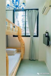 een kamer met een stapelbed en een raam bij Chengdu Zhengfu Cao Tang Inn in Chengdu