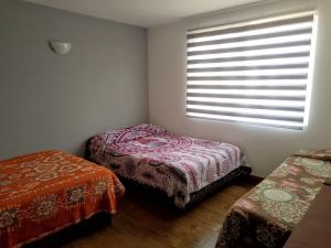 1 dormitorio con 2 camas individuales y ventana en Quinta Residencial El Colibrí en San Martín de las Pirámides