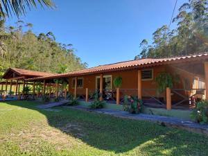 a house with a grass yard in front of it at Pousada Fazenda Vale Verde in Sete Barras