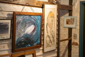 a wall with paintings and pictures on it at Haryugetu Guesthouse in NASA in Kaiyo