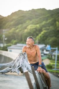 an older man sitting on a rail at a skate park at Haryugetu Guesthouse in NASA in Kaiyo