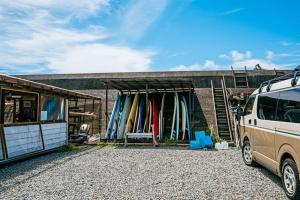 a van parked in front of a building with surfboards at Haryugetu Guesthouse in NASA in Kaiyo