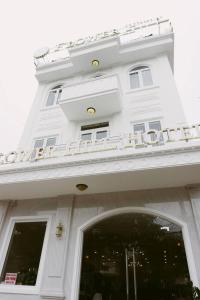 een wit gebouw met een bord erop bij Flower Hill in Da Lat